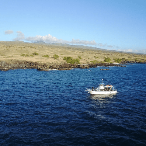 A small boat is floating on top of a large body of water.