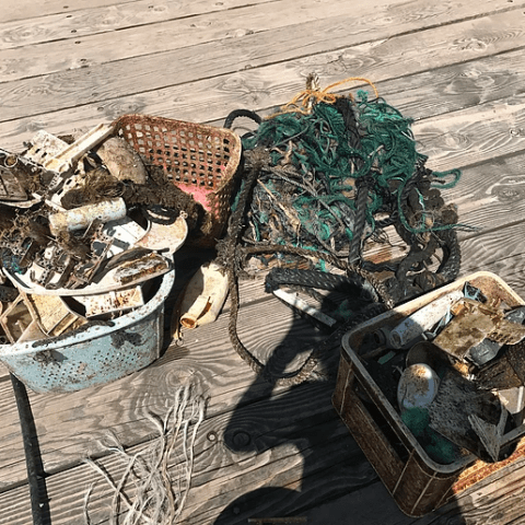 A pile of trash is sitting on a wooden deck.