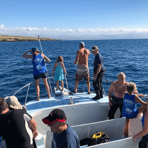 A group of people are on a boat in the ocean.