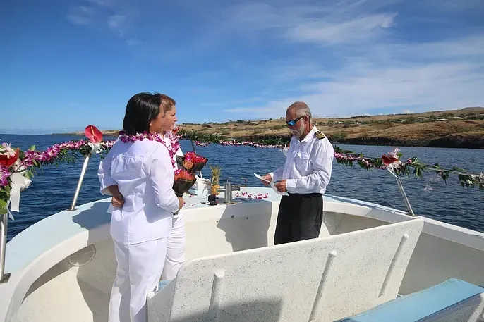 A man and a woman are standing on a boat in the ocean.