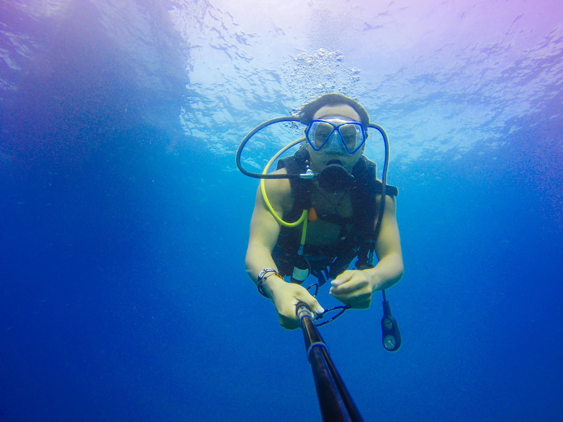 A man is taking a picture of himself while scuba diving in the ocean.