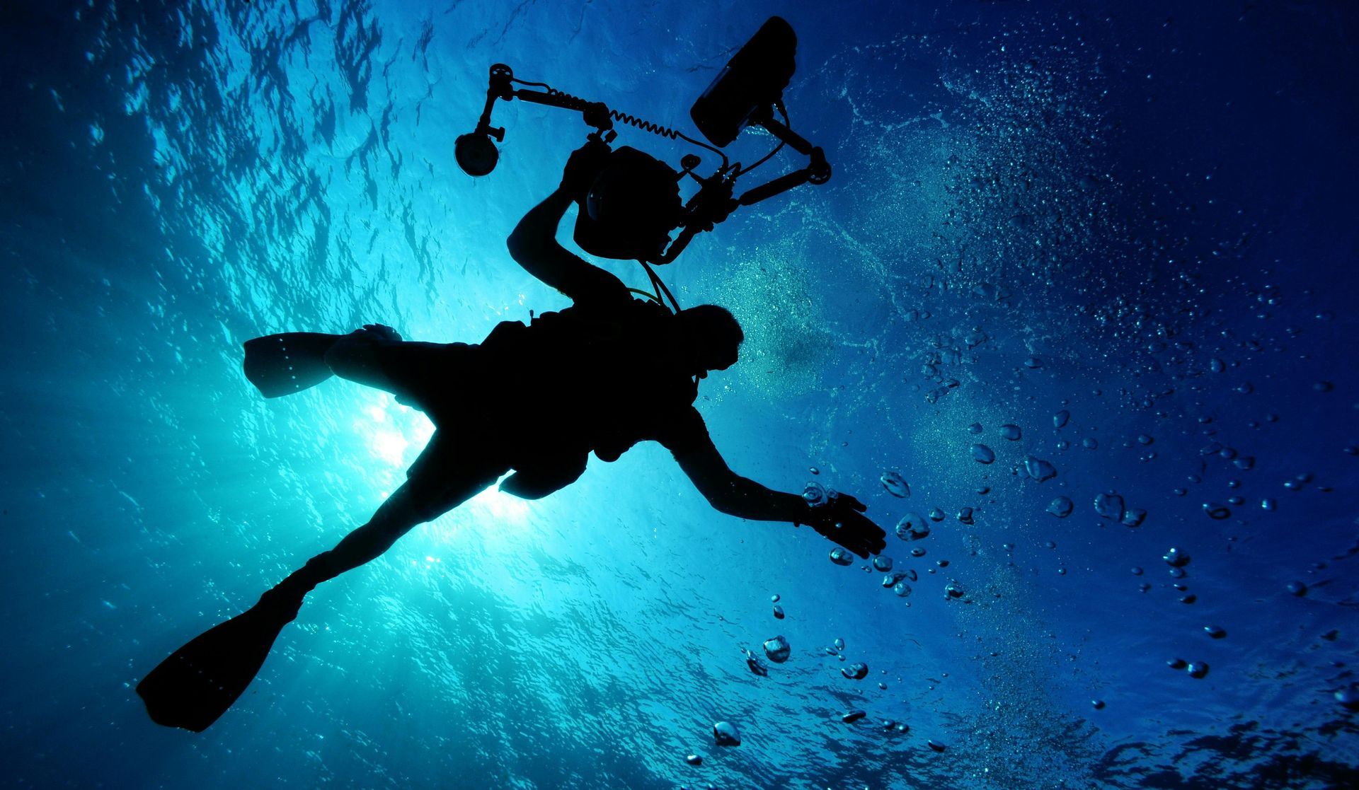 A silhouette of a scuba diver in the ocean.