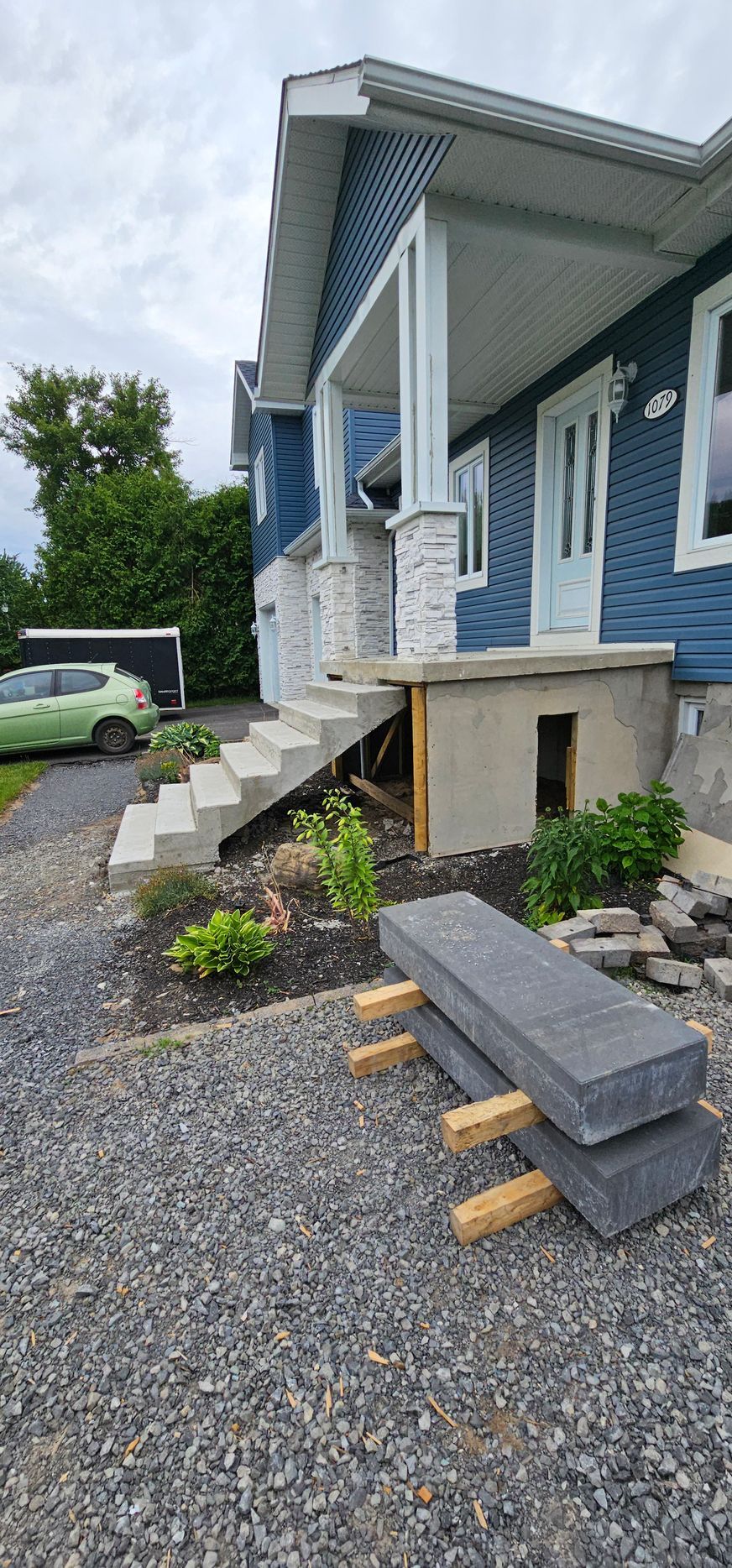 Une maison bleue avec des escaliers en construction devant elle.