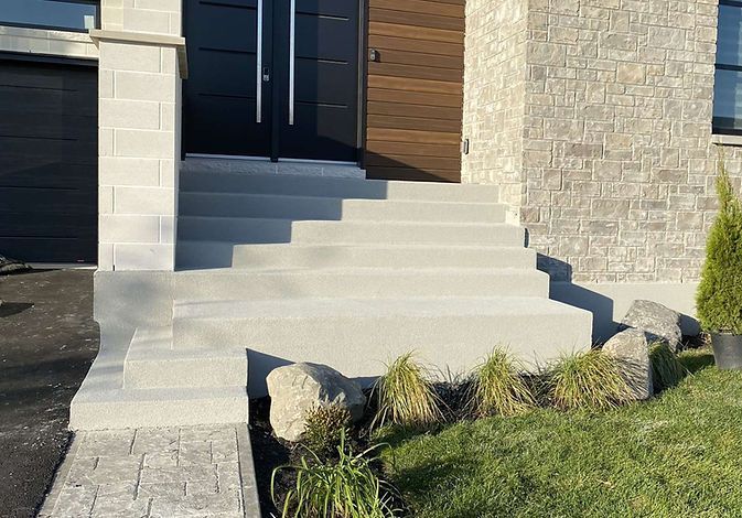 Une maison avec des escaliers menant à la porte d'entrée.