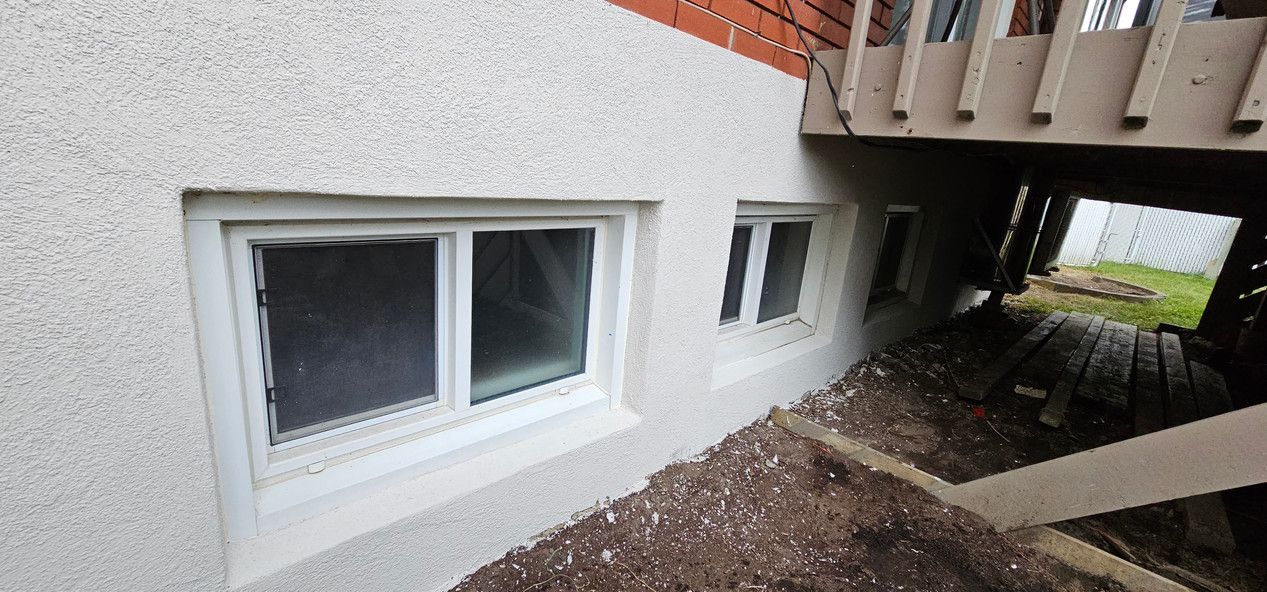 Il y a deux fenêtres sur le côté d'une maison.