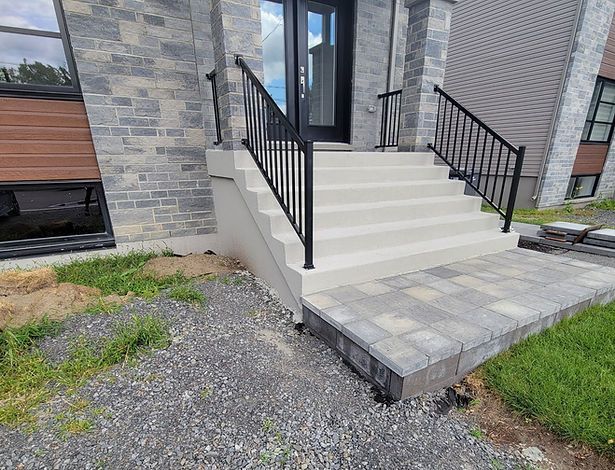 Il y a des escaliers qui mènent à la porte d'entrée d'une maison.