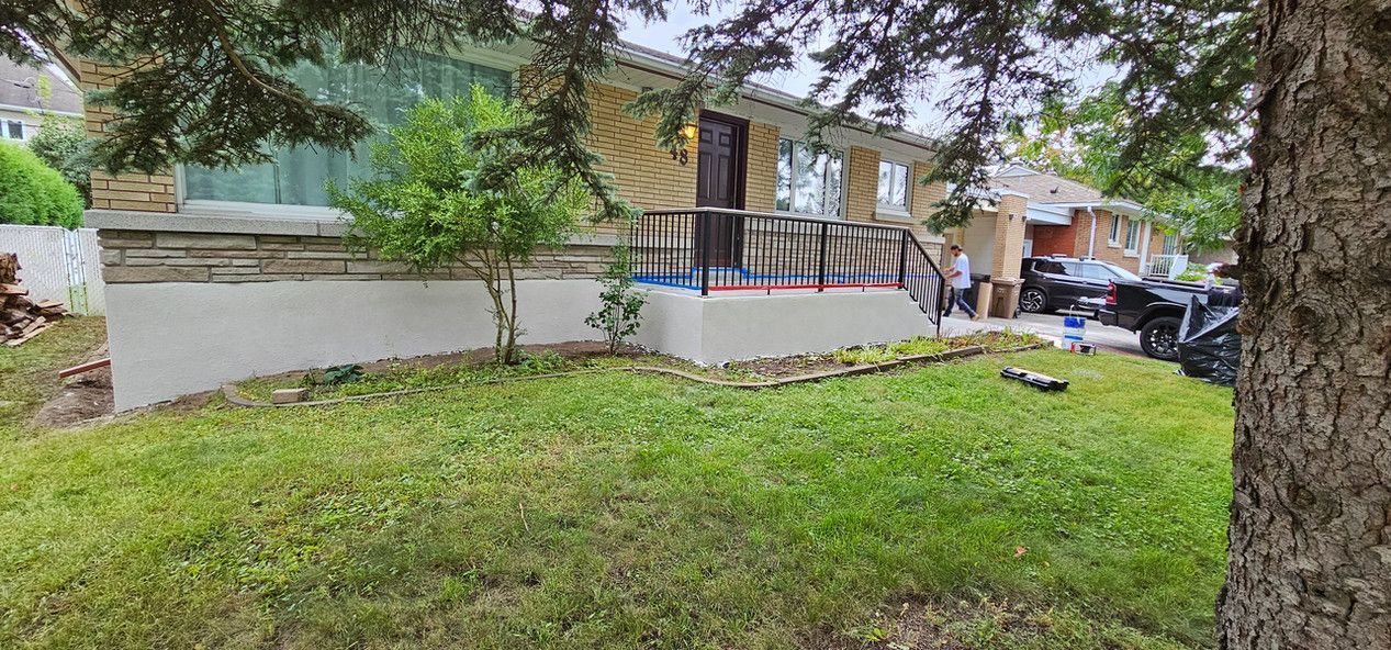 Une maison avec une grande pelouse et un arbre devant.