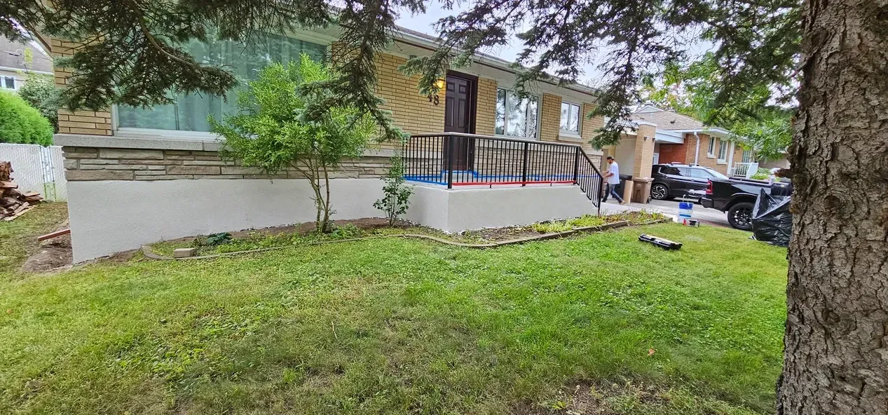 Une maison avec une grande pelouse et un arbre devant.