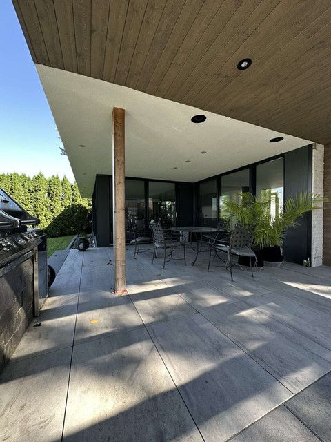 Un patio avec un grill et des chaises dessus