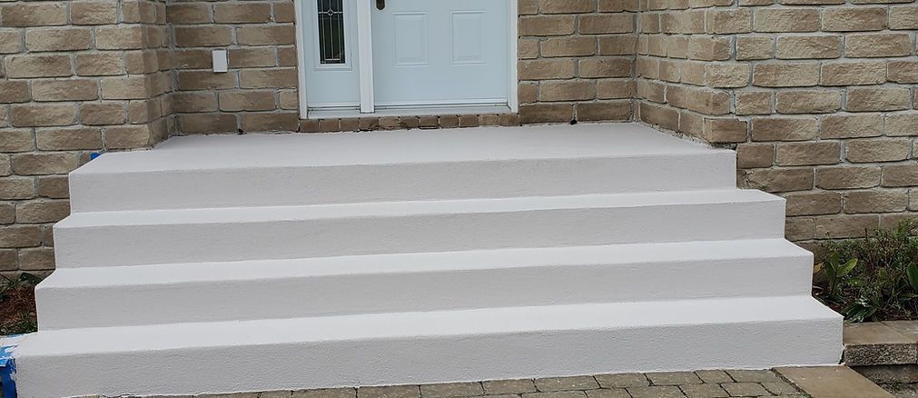 Un ensemble d'escaliers blancs menant à un bâtiment en briques.