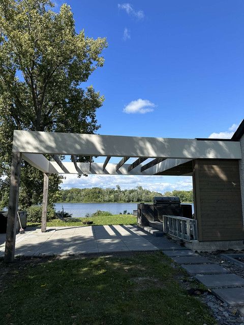Un camion est garé sous une pergola surplombant un lac.