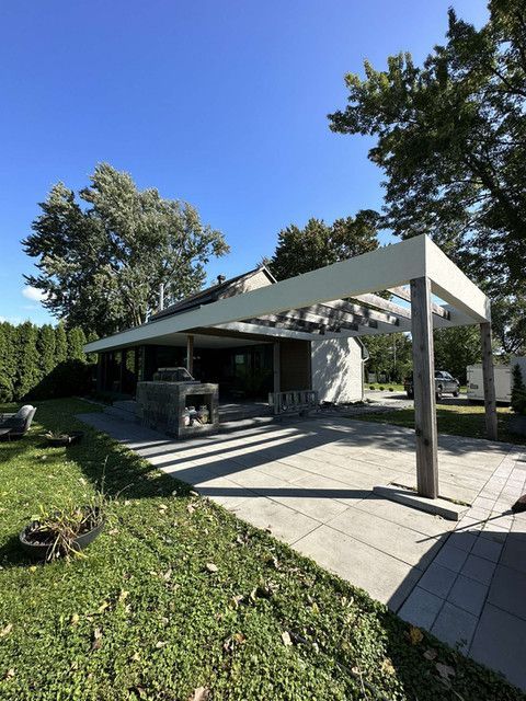 Une maison avec une pergola et un patio devant