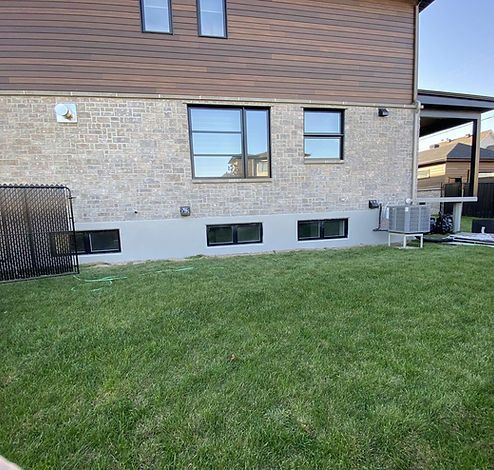 Une grande maison en briques avec une grande pelouse devant.