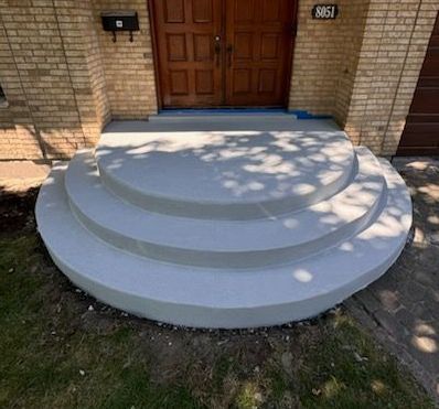 Un ensemble de marches en béton menant à une maison en briques.