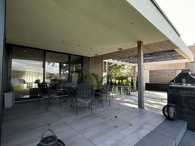 Un patio avec une table et des chaises sous un auvent.