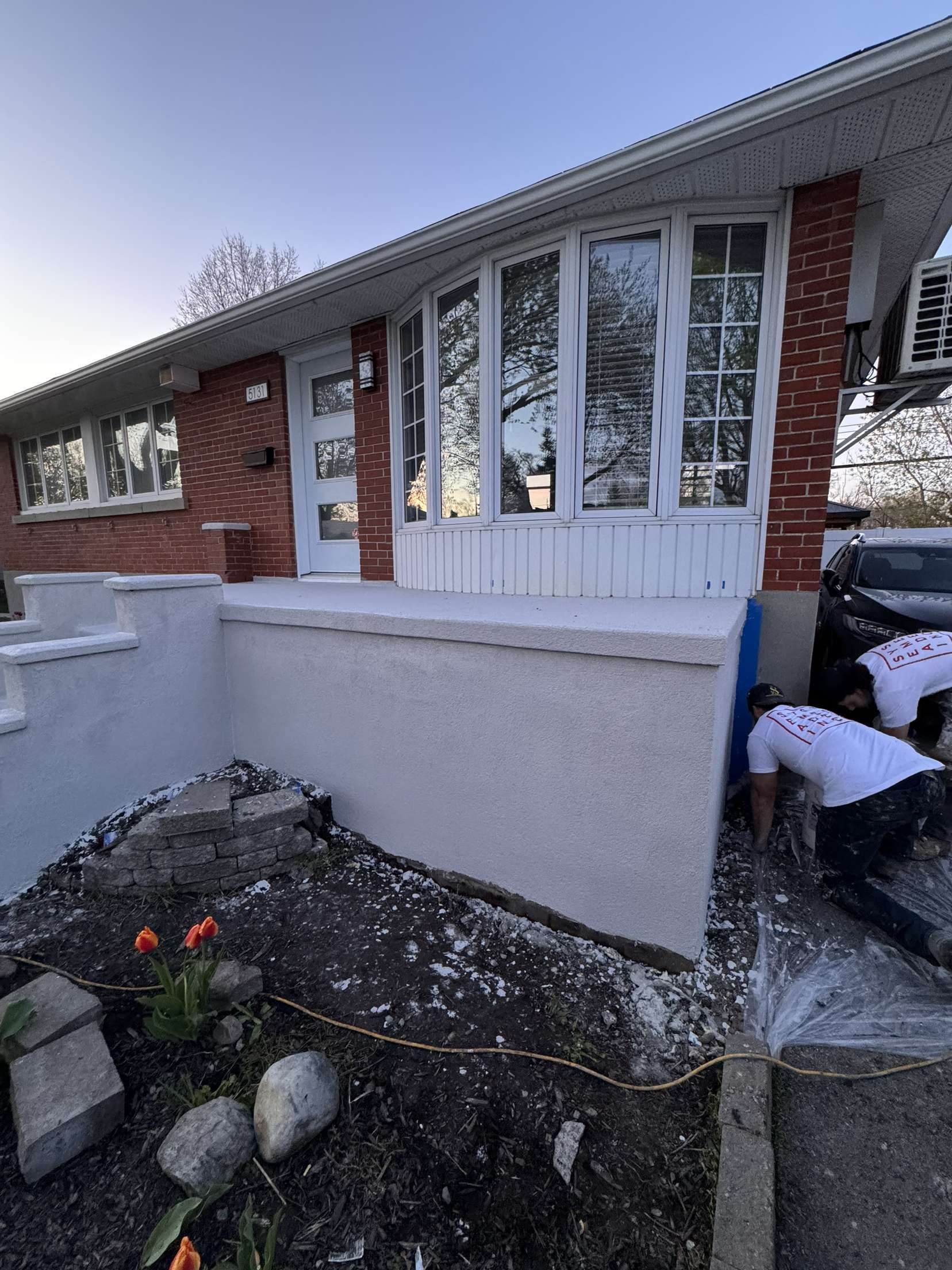 Un couple d'hommes travaille sur la façade d'une maison.