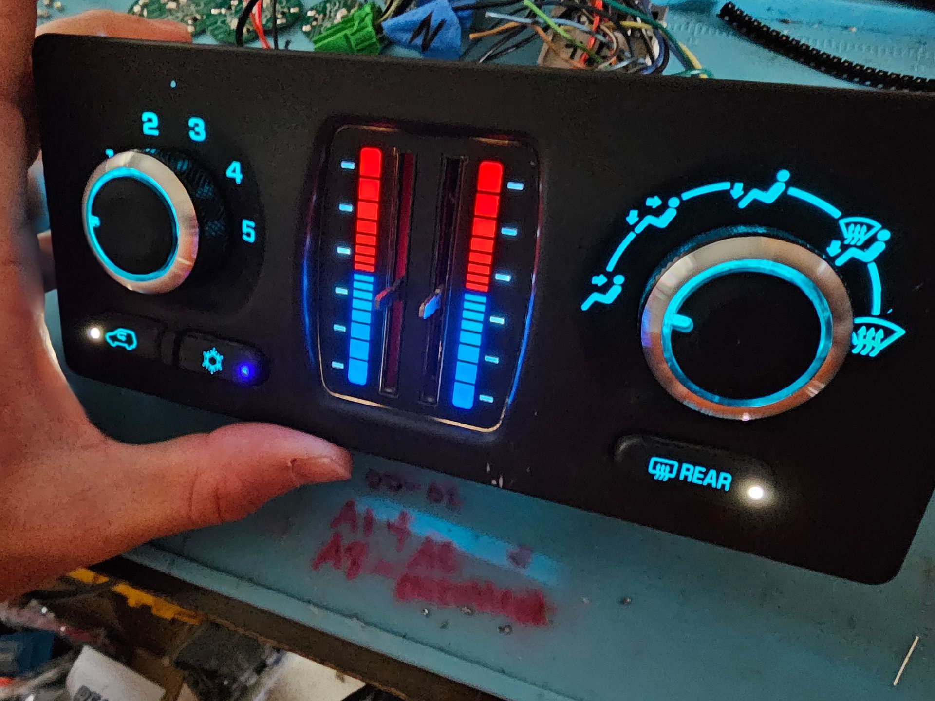 A person is holding a rear climate control panel