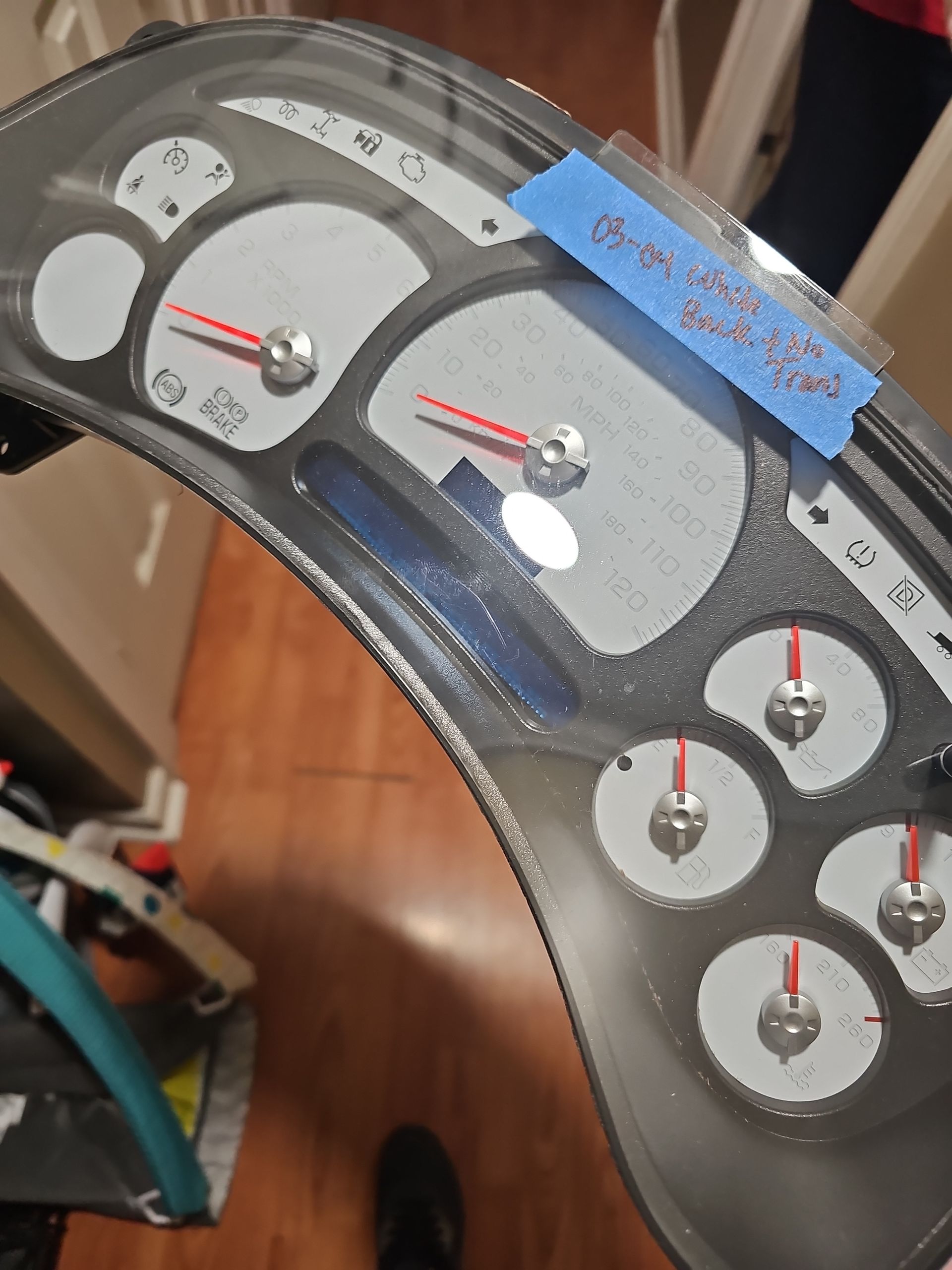 A close up of a speedometer with a blue tape on it