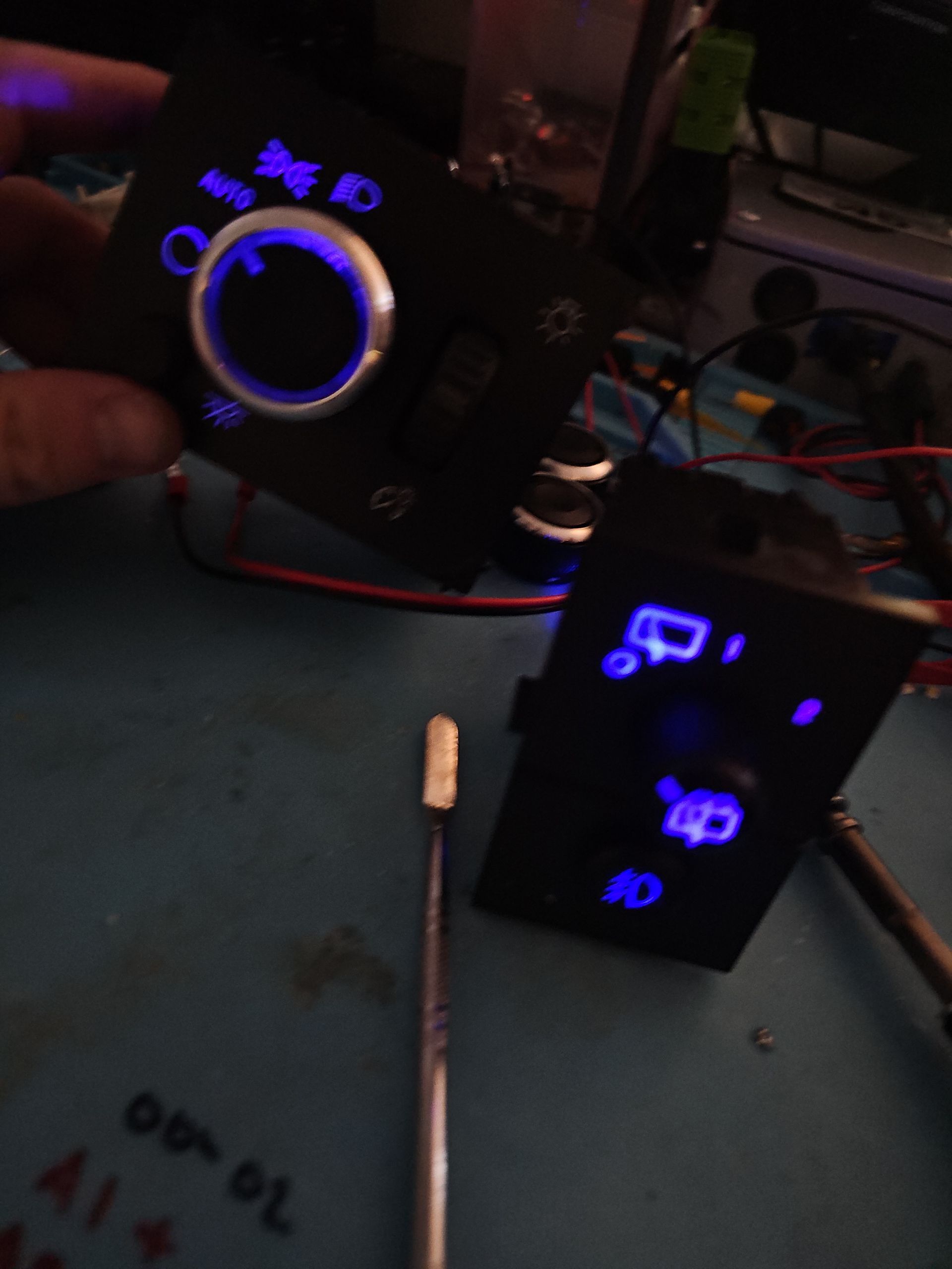A person is holding a device that has a blue light on it
