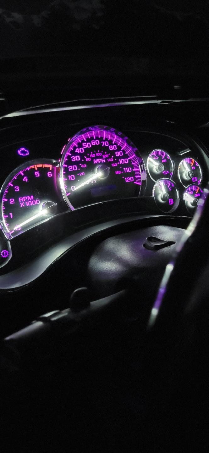 The dashboard of a car with purple lights on it.