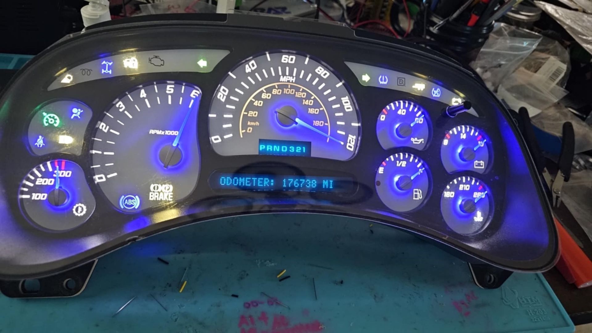 A car dashboard is sitting on top of a blue table.