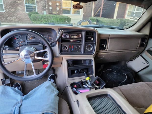 A person is sitting in the driver 's seat of a car.