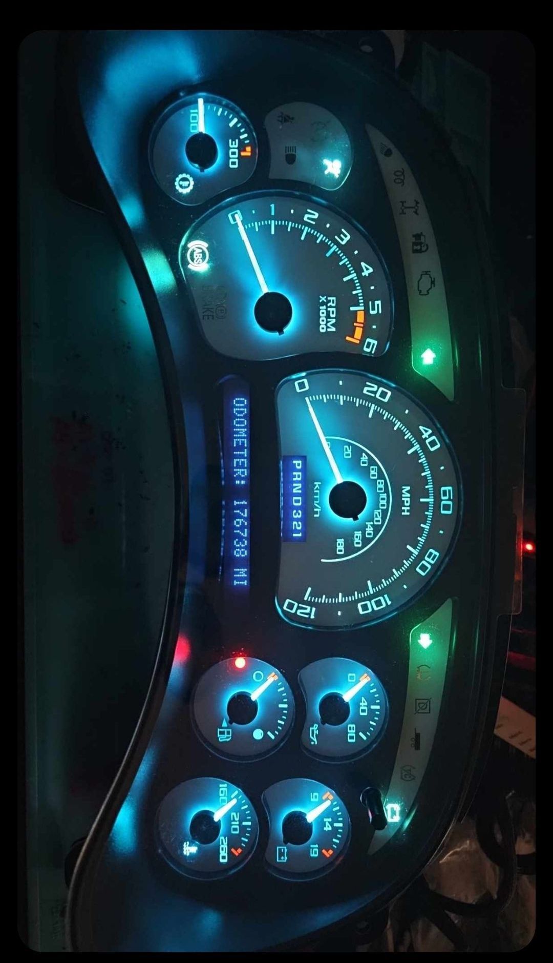 A close up of a car dashboard with a blue light on it