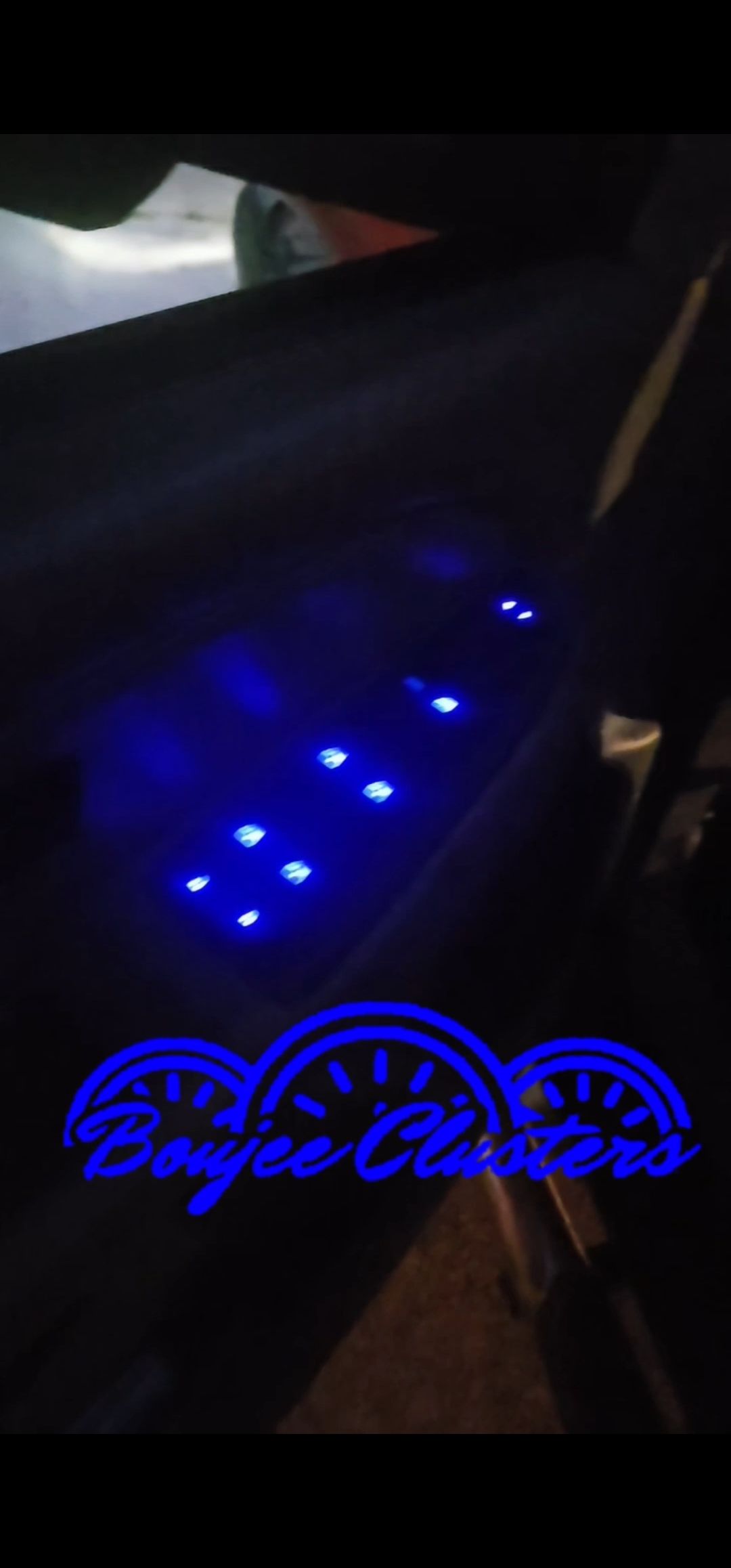The inside of a car with blue lights on the door panel