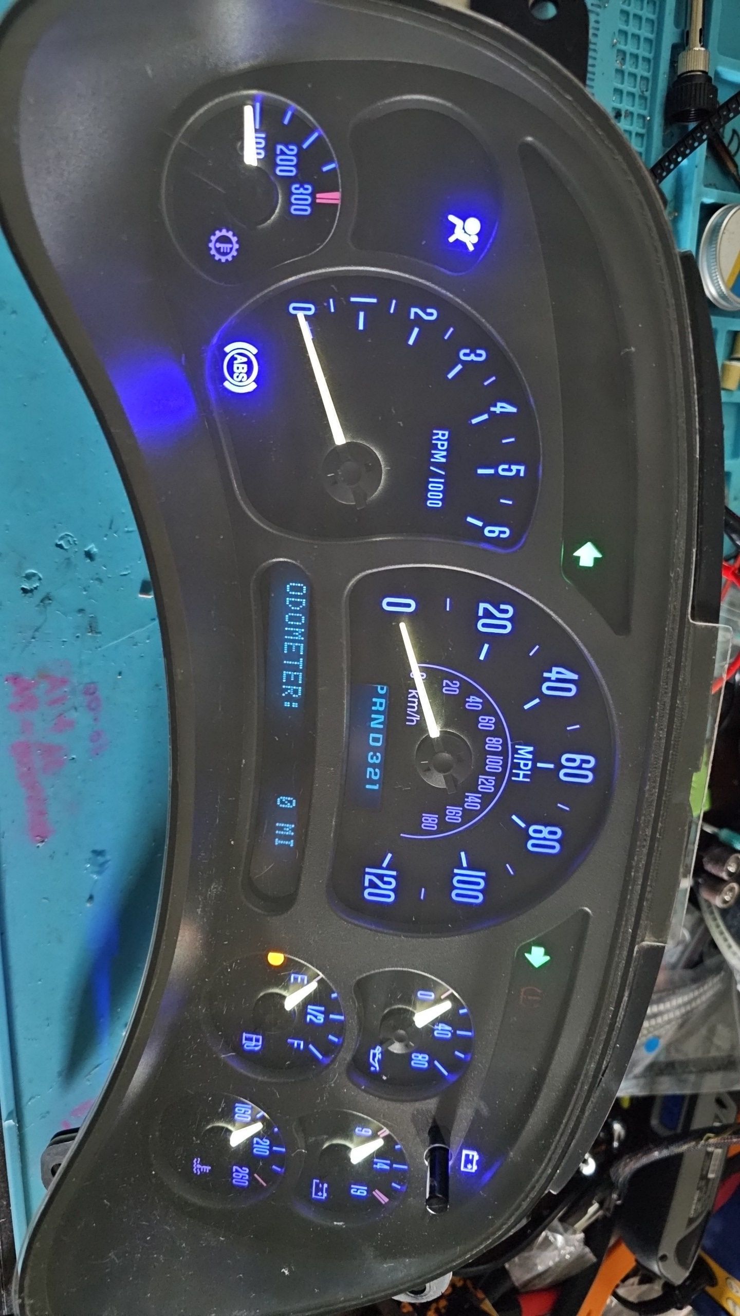 A close up of a car dashboard with a blue light on it