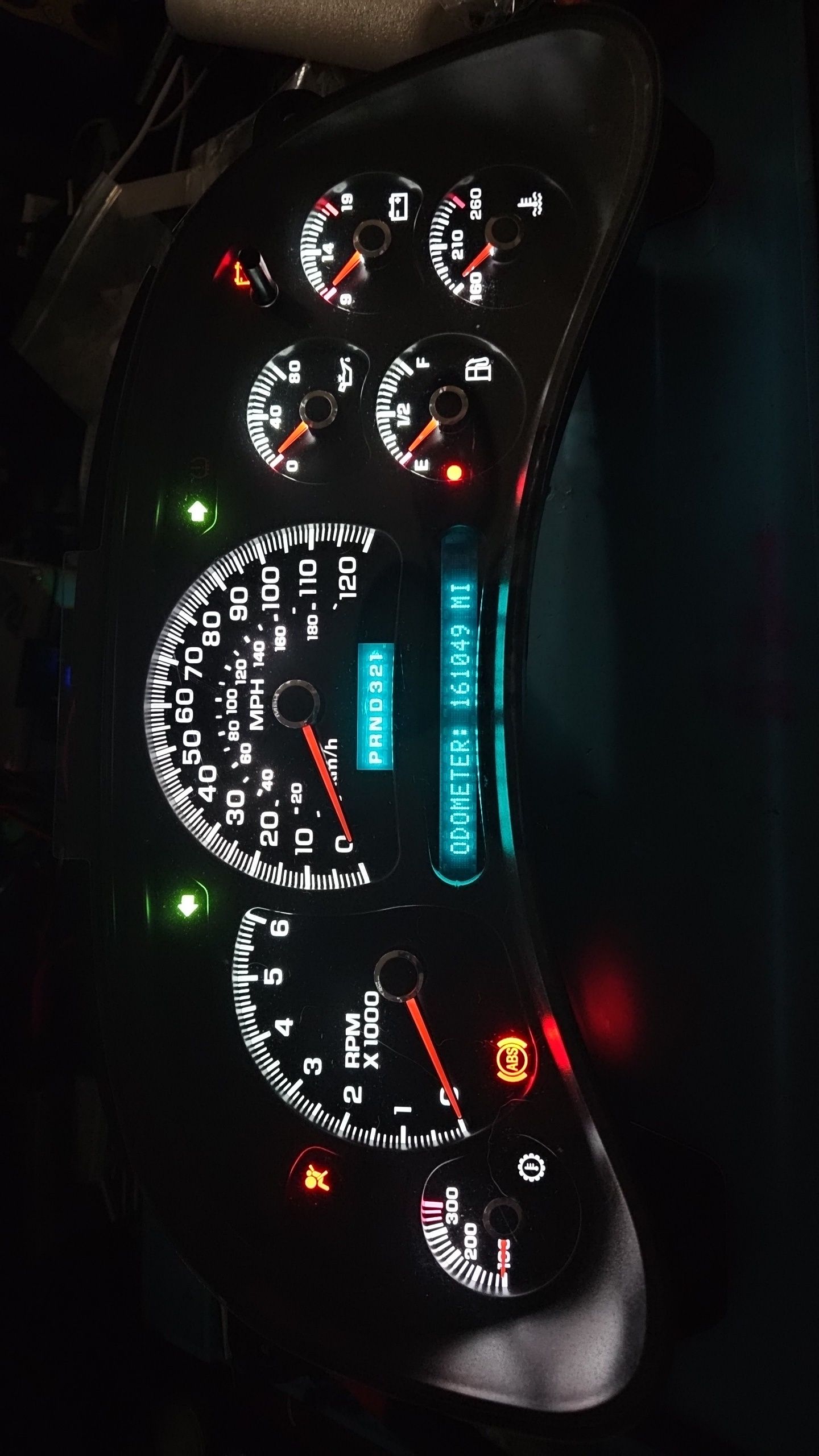 A close up of a car dashboard with a speedometer and a tachometer