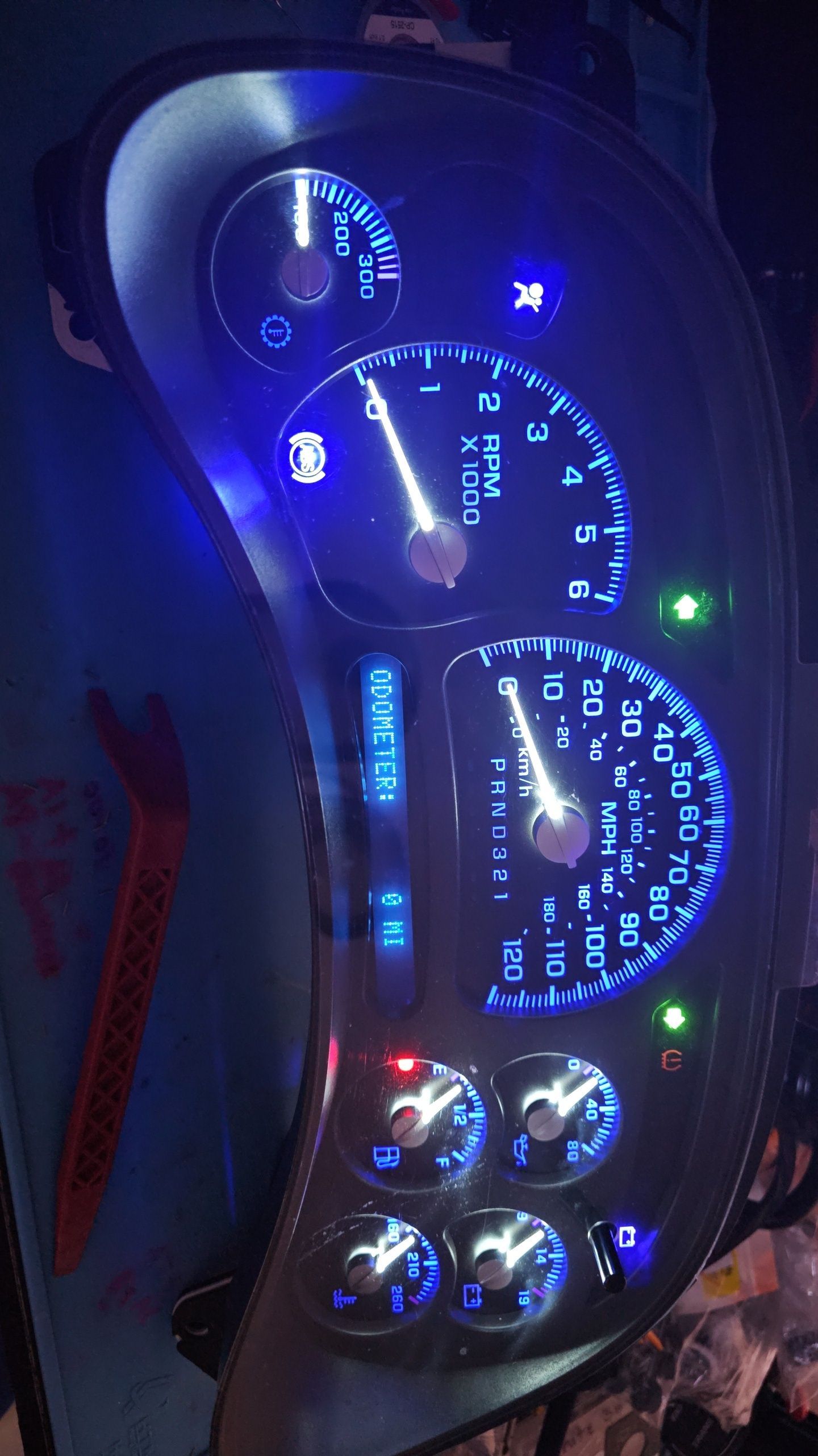 A close up of a car dashboard with blue lights on it.