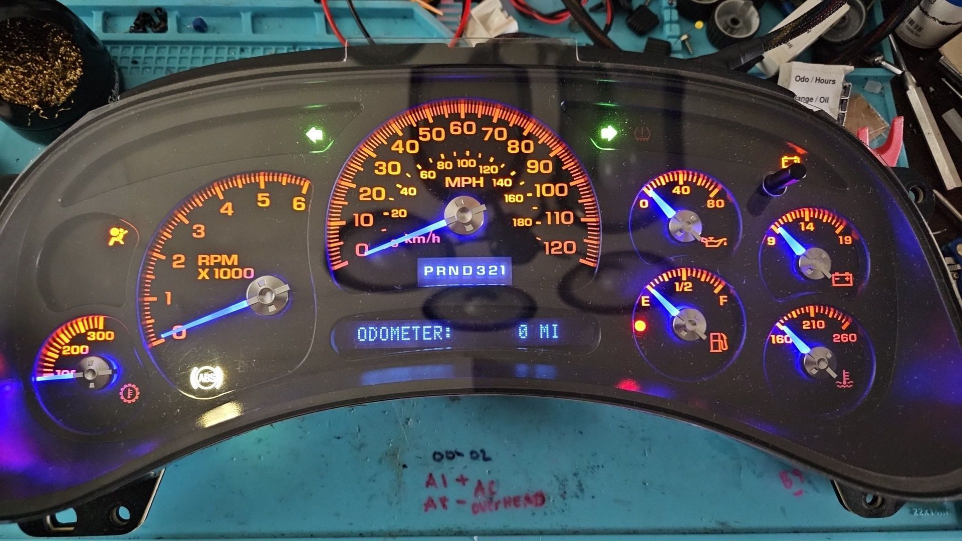 A dashboard with a lot of gauges on it is sitting on a table.