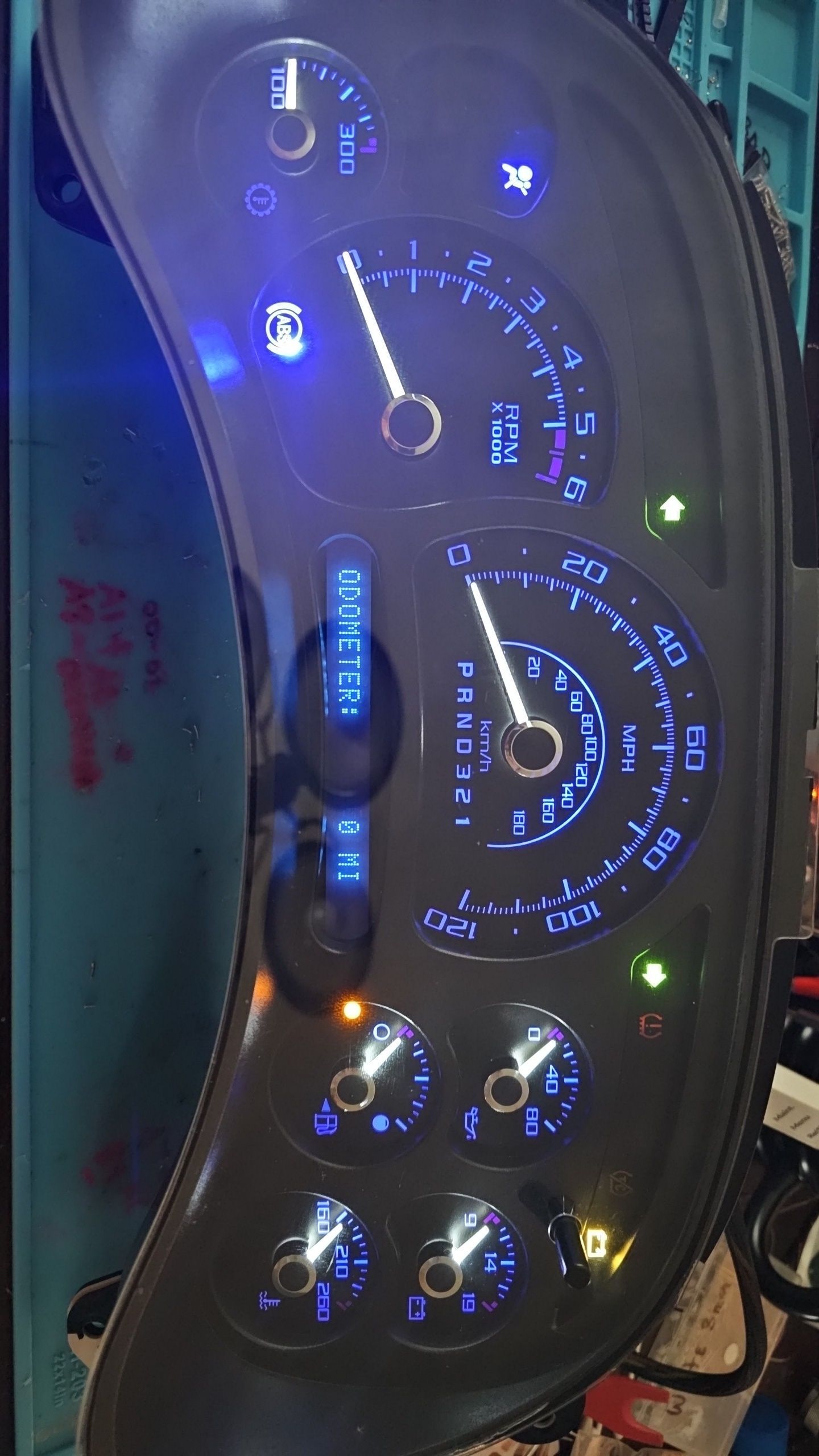 A close up of a car dashboard with blue lights on it.