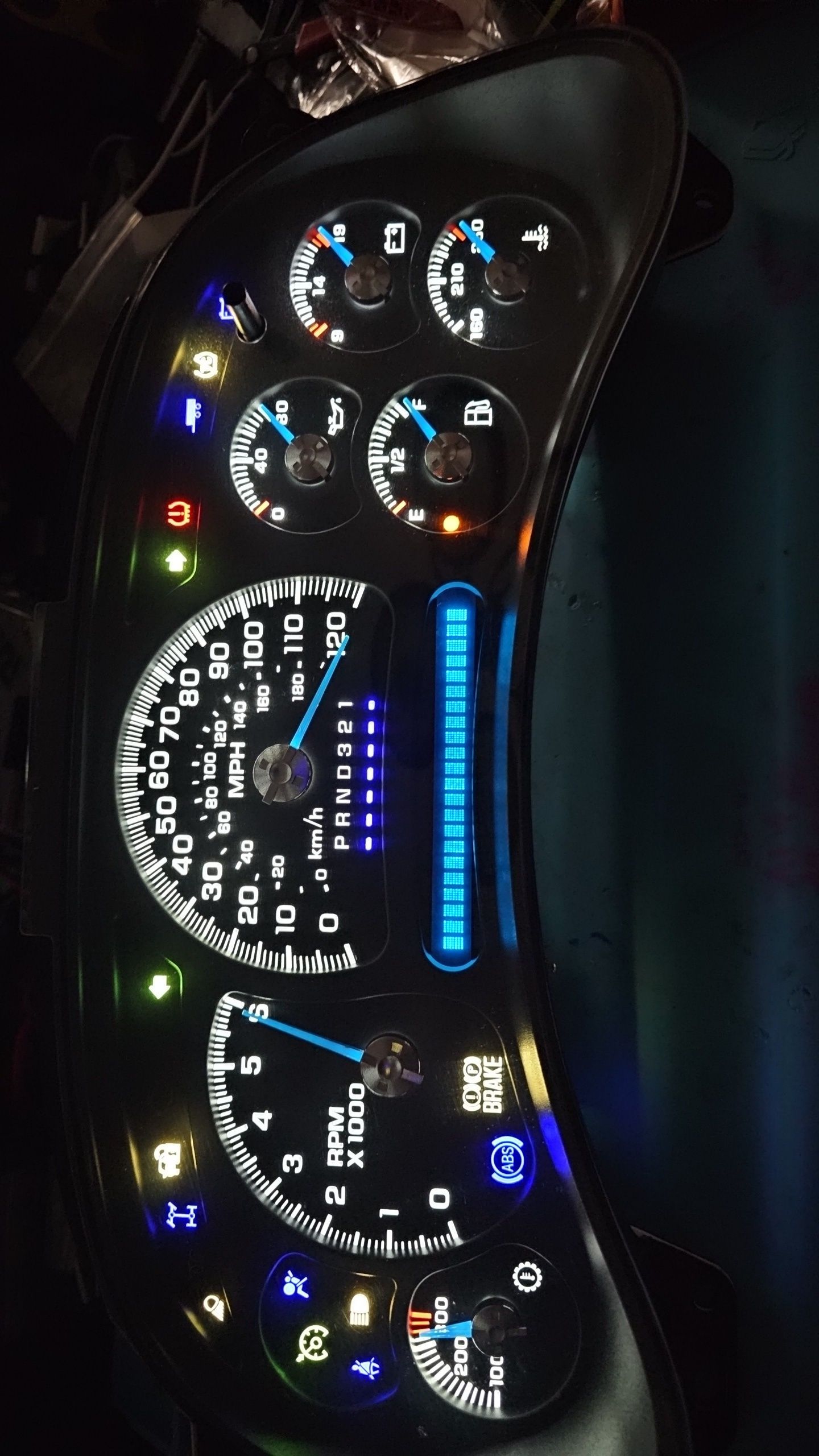 A close up of a car dashboard with a tachometer and a speedometer
