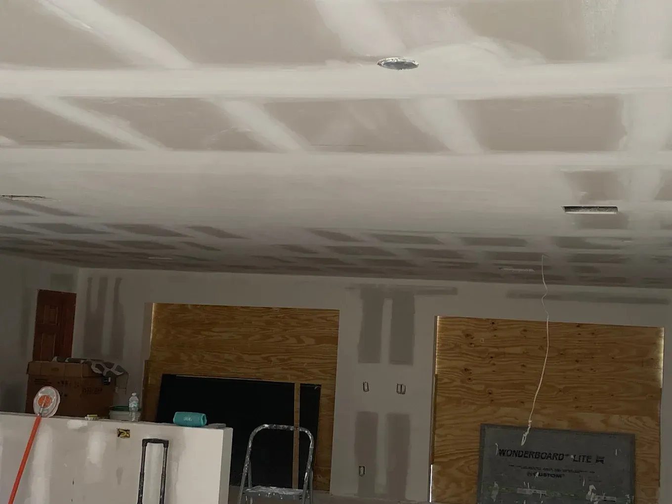 A room with a white ceiling and a ladder in it