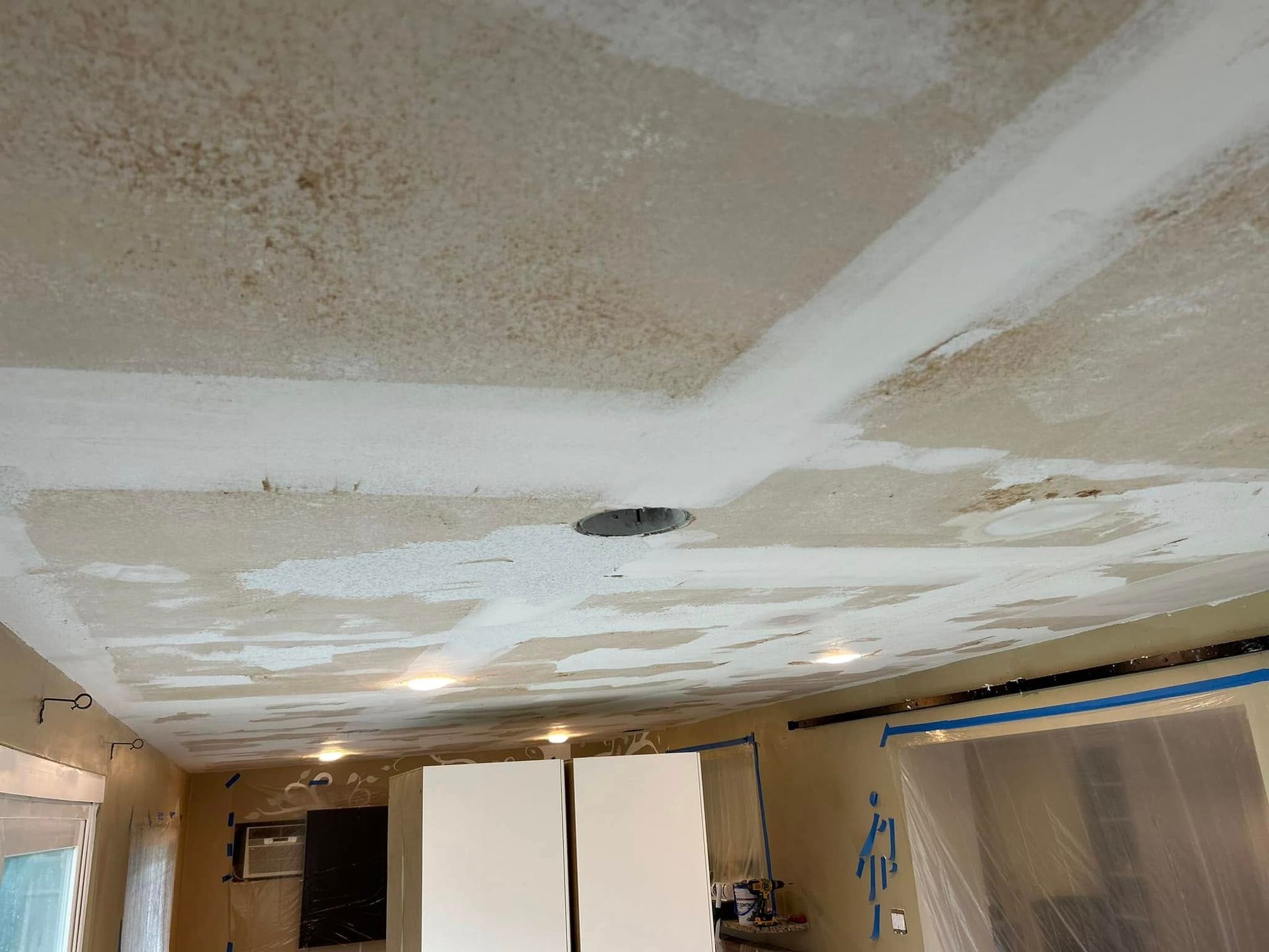 A room with a ceiling that is being painted white.