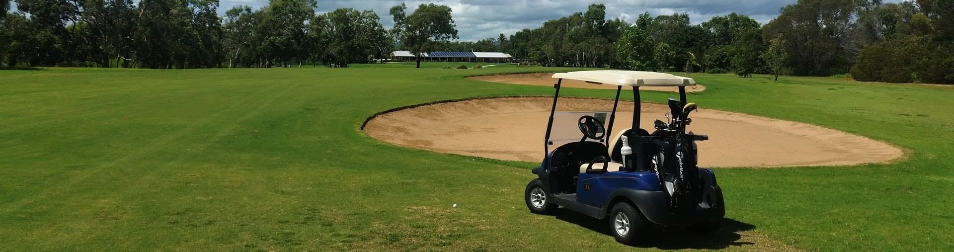 A Golf Cart Is Parked In The Grass On A Golf Course — Rowes Bay Golf Club In Rowes Bay, QLD