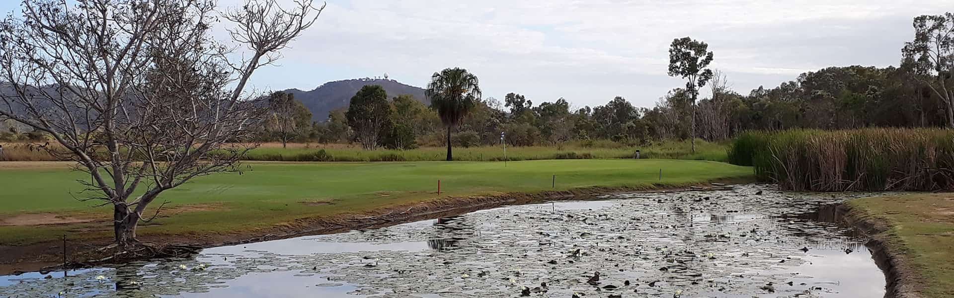 A Muddy Pond In The Middle Of A Field Next To A Golf Course — Rowes Bay Golf Club In Rowes Bay, QLD