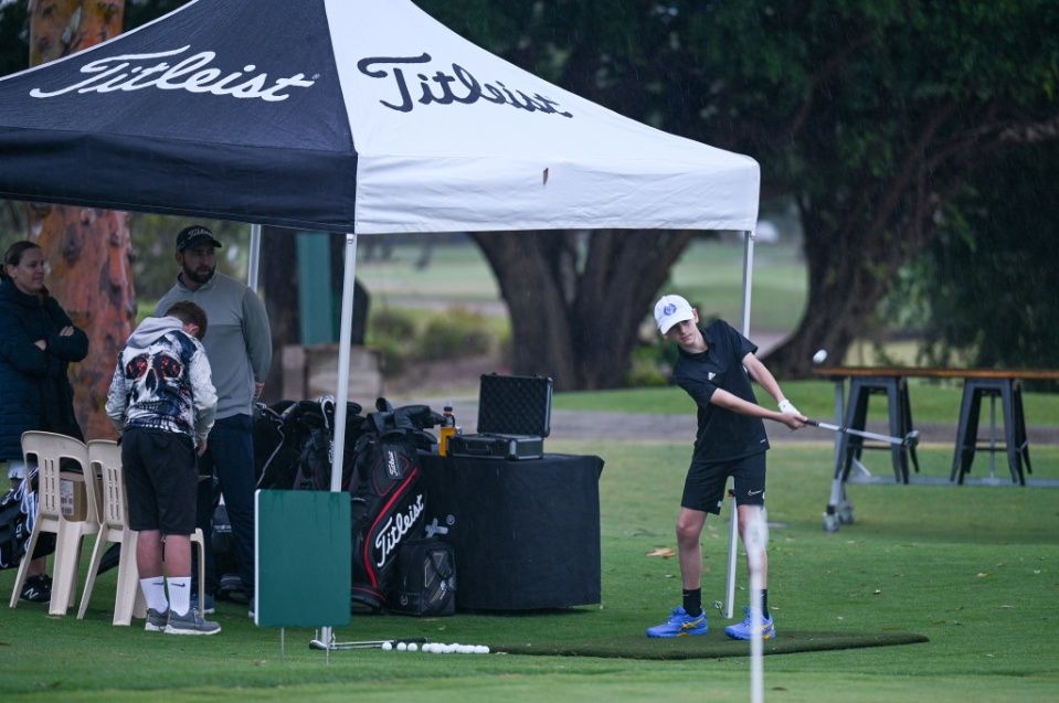 A Man Is Swinging A Golf Club On A Golf Course Under A Tent — Rowes Bay Golf Club In Rowes Bay, QLD
