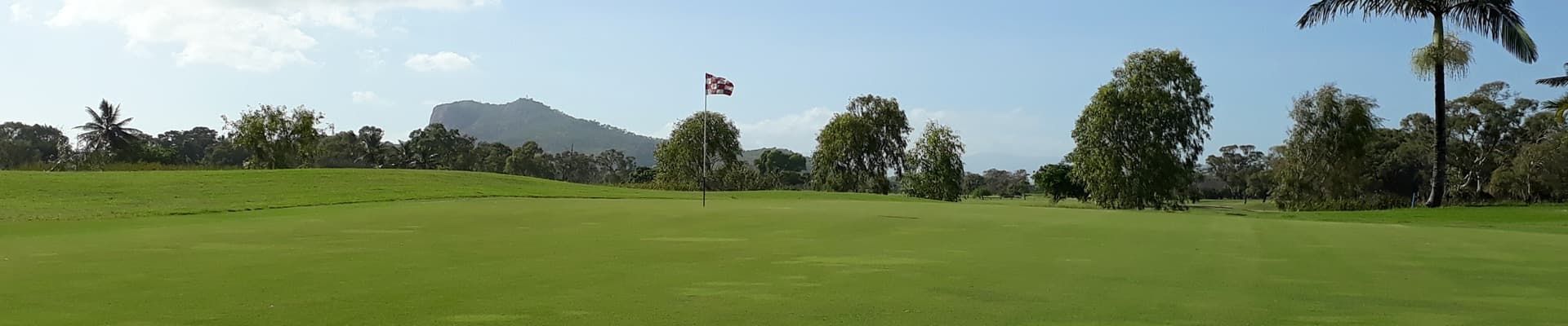 A Image Of A Golf Course With Trees And Mountains In The Background — Rowes Bay Golf Club In Rowes Bay, QLD