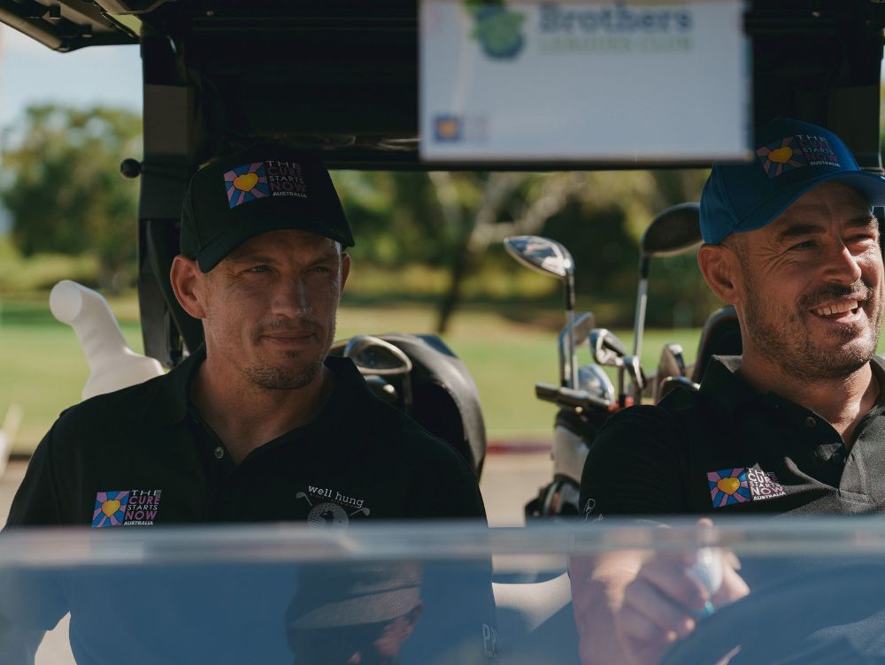 Two men are sitting in a golf cart on a golf course.— Rowes Bay Golf Club In Rowes Bay, QLD