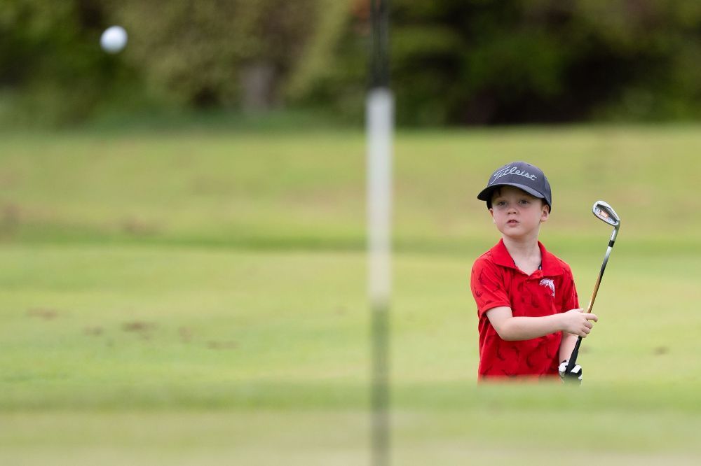A Golf Club Is Sitting Next To A Golf Ball On A Green — Rowes Bay Golf Club In Rowes Bay, QLD