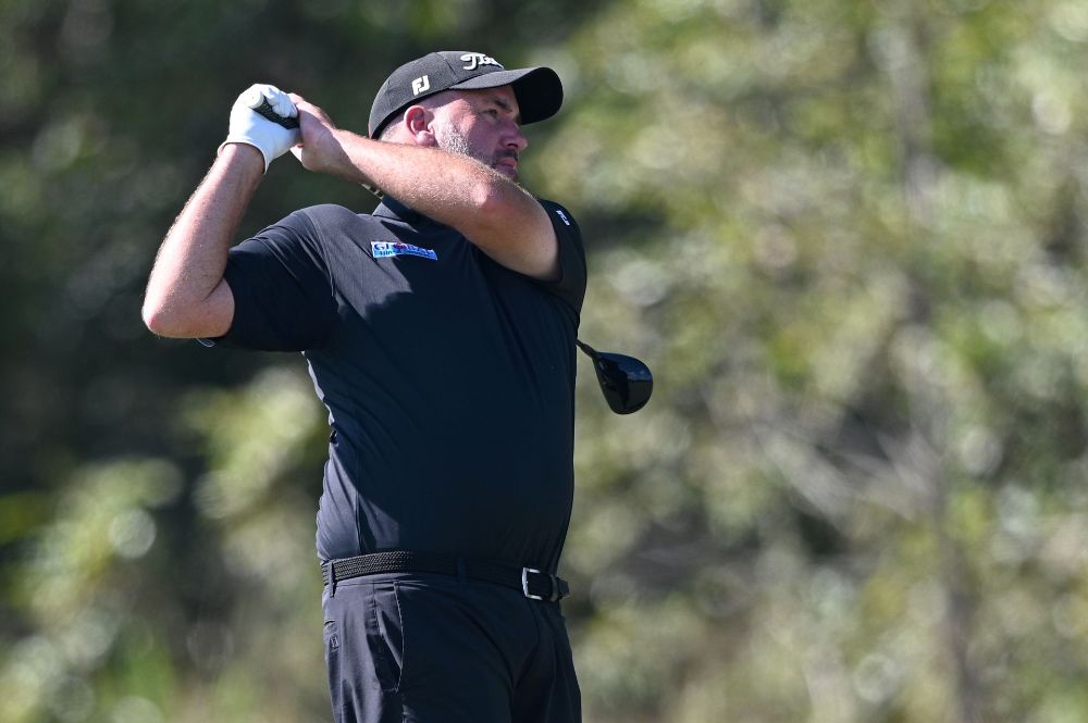 A man is swinging a golf club on a golf course— Rowes Bay Golf Club In Rowes Bay, QLD