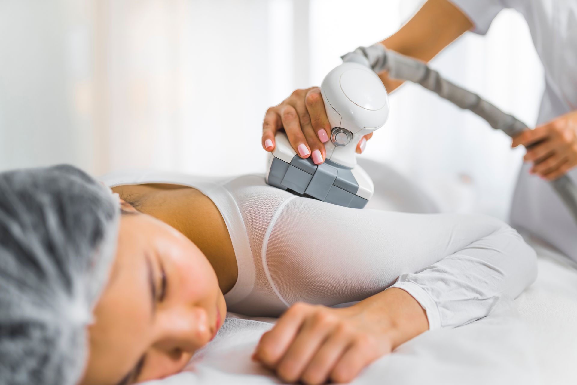 Spa therapist using a handheld device on a client’s back during a treatment
