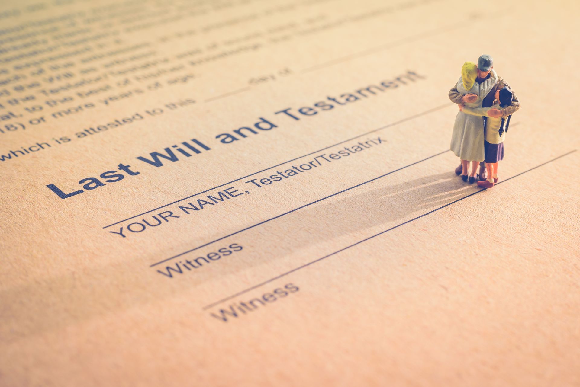 Two miniature figures standing on a document titled Last Will and Testament, with lines for a name and witnesses. Two miniature figures standing on a document titled Last Will and Testament, with lines for a name and witnesses.
