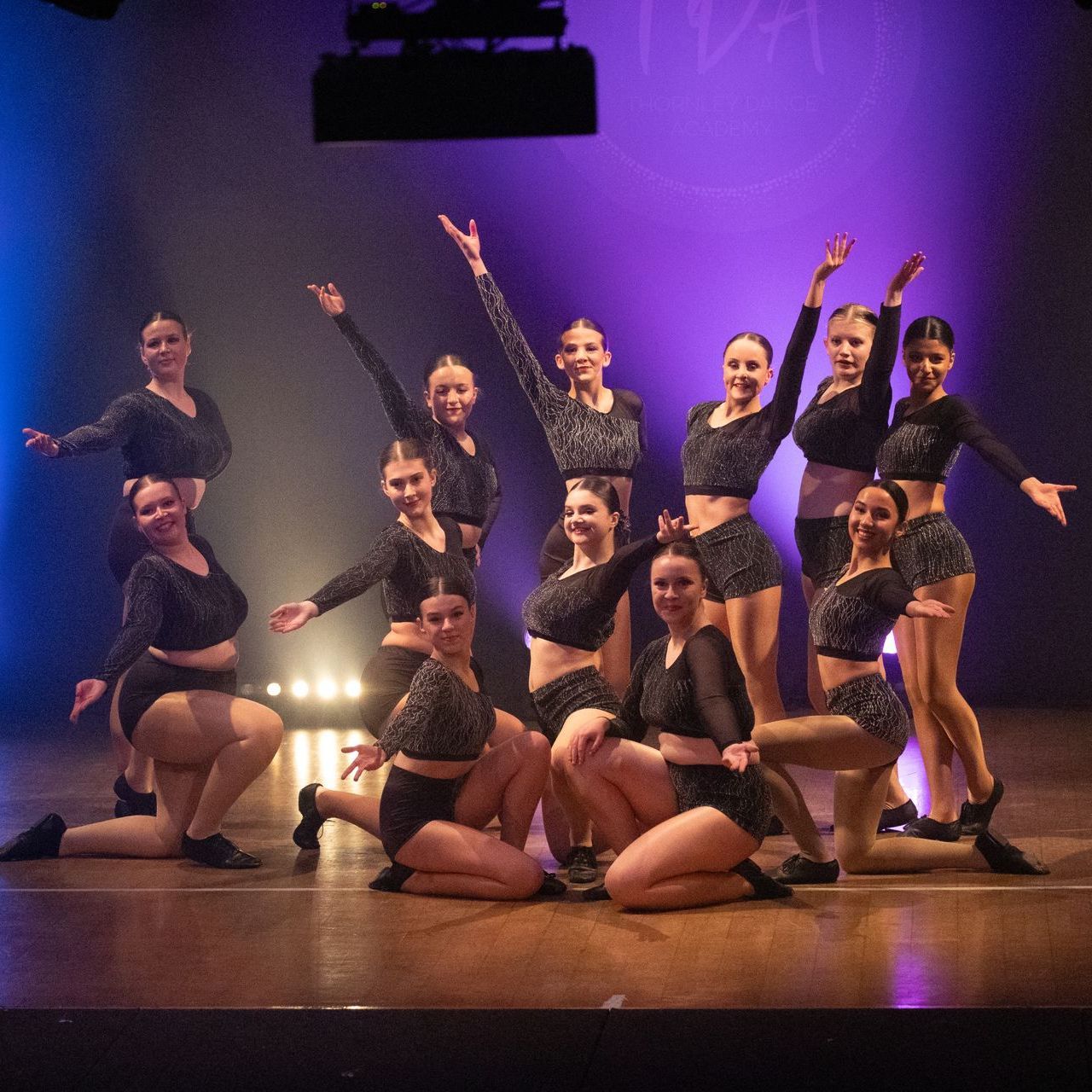 A group of women are posing for a picture on a stage