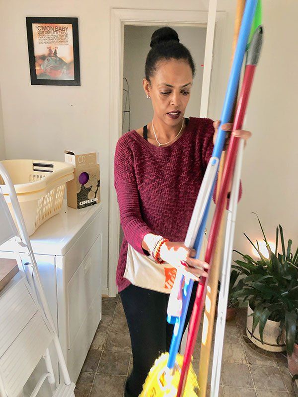 Woman Holding Cleaning Equipments — Vienna, VA — Fairfax Estate Sales TFV