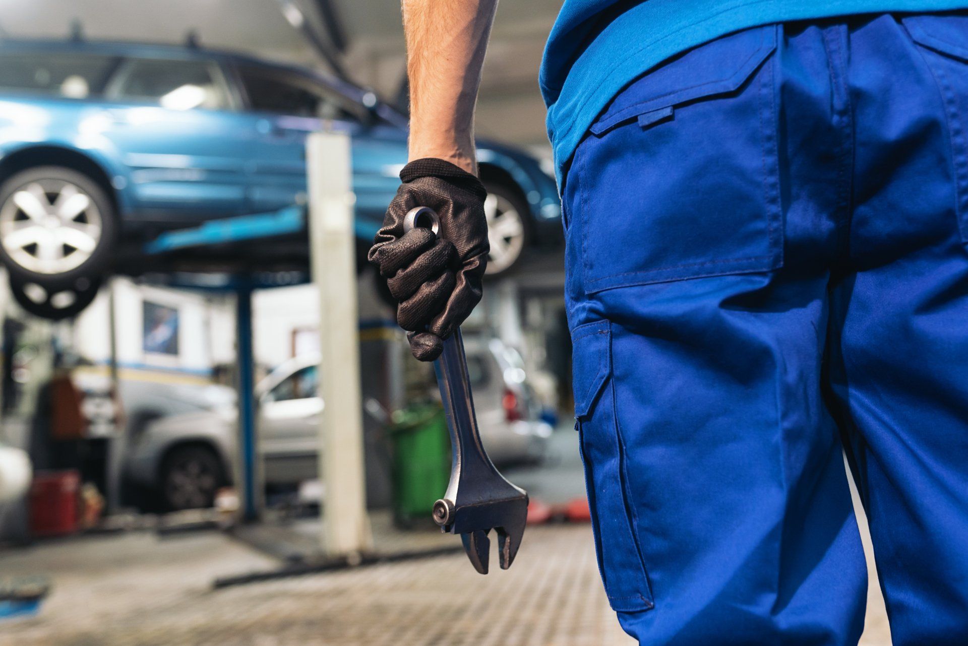 Mechanic In Blue Uniform Holding Wrench Tool — Automotive Repair in Townsville