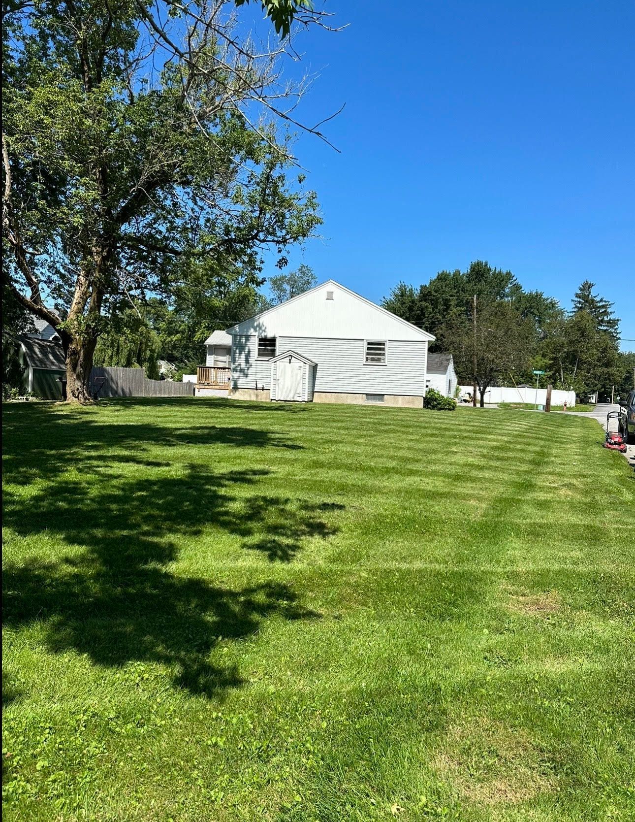 a white house is sitting in the middle of a lush green field.