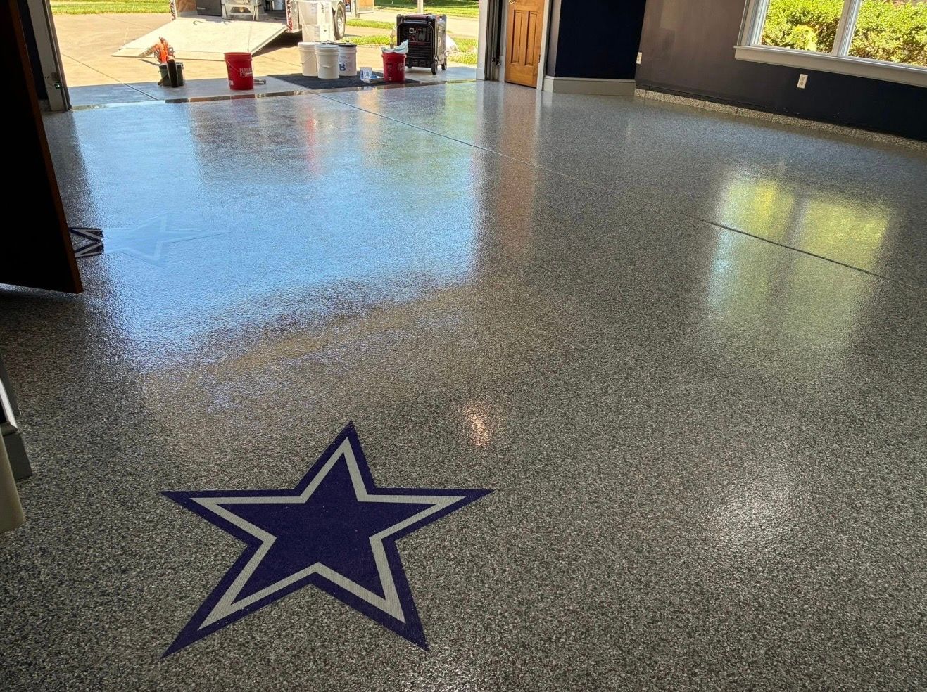 Indoor polished floor with a large Dallas Cowboys star logo in the foreground and an open entryway beyond.